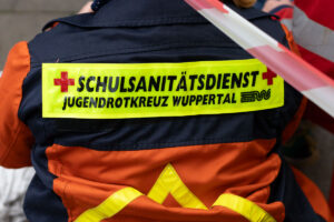 Rückenschild ‚Schulsanitätsdienst‘ auf einer Jacke.