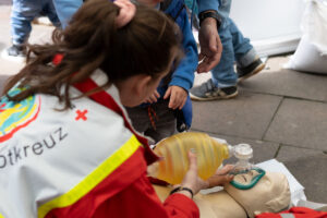 JRK-Mitglied demonstriert an einer Übungspuppe das Anlegen eines Ambu-Beutels