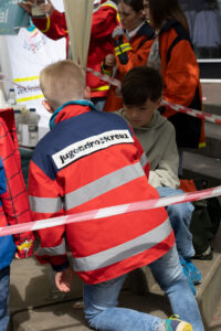 Jugendrotkreuz Mitglied beugt sich nach vorne